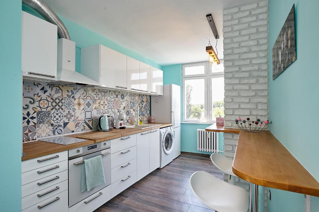 瓦尔纳Sunset Smart Home的厨房配有白色橱柜和蓝色的墙壁