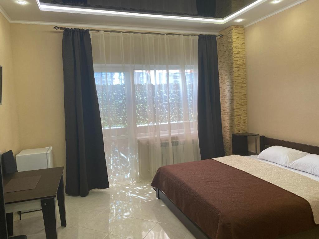 敖德萨Міні-готель "Кімната Комфорт"的一间卧室设有一张床和一个大窗户