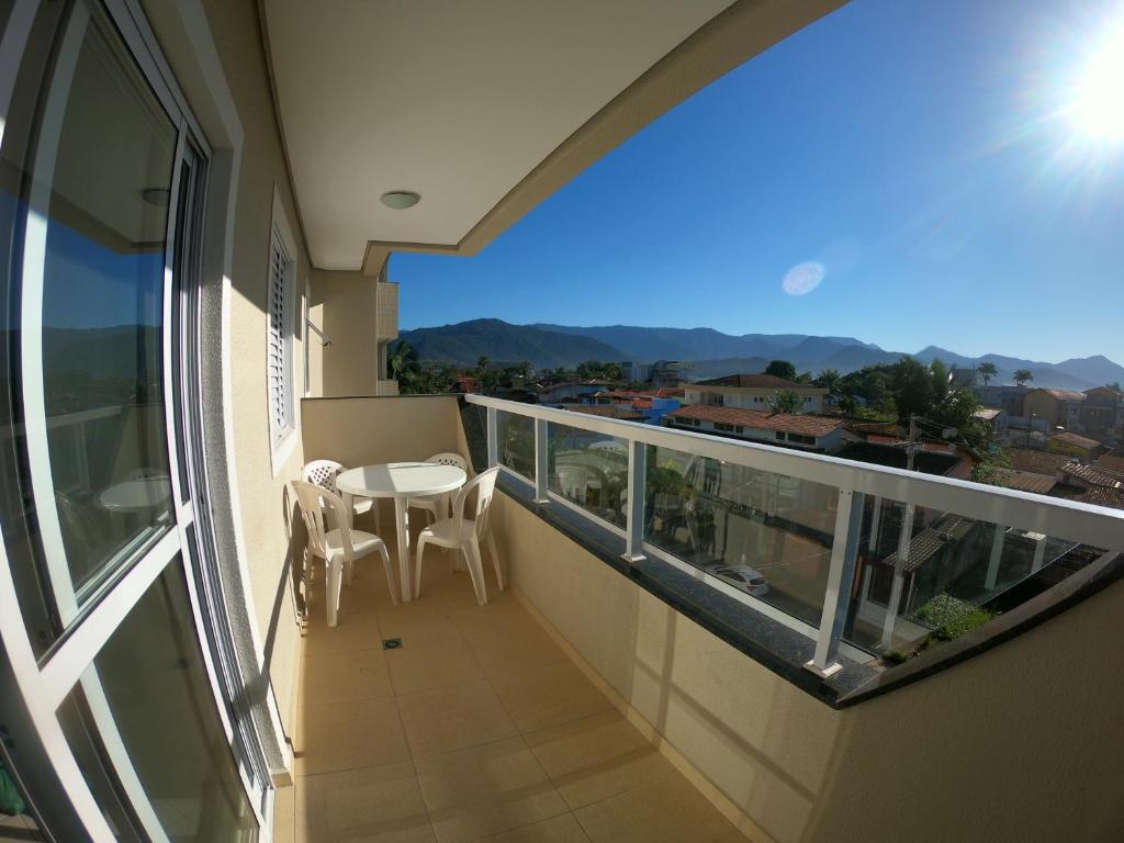 乌巴图巴Beach House Itaguá Apartamento 1 - Em Ubatuba a 300m da orla mais charmosa, com excelente localização的设有一个配有桌椅并享有美景的阳台。