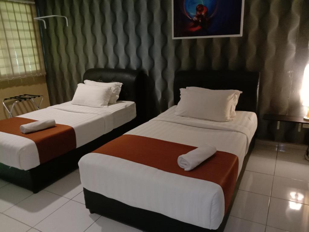 龙运NDE Hotel的配有两张床的酒店客房中的两张床