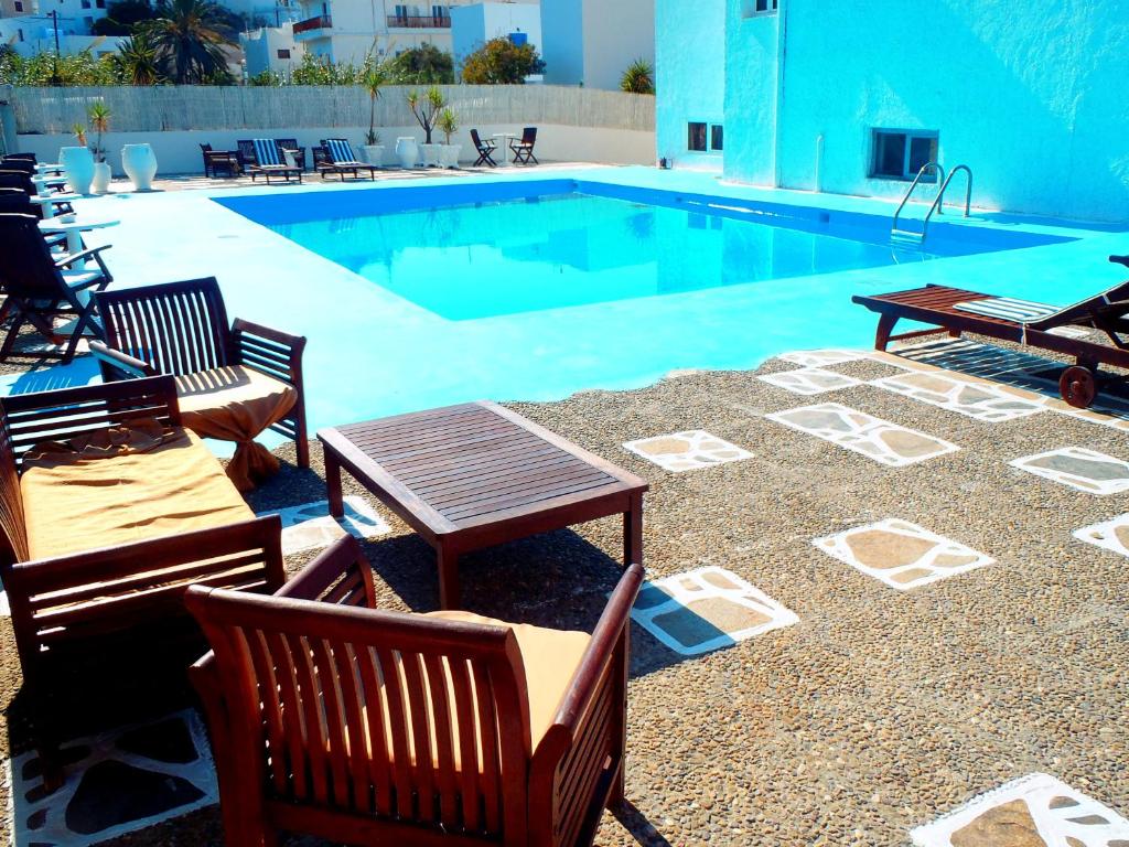 阿达玛斯里奥格玛酒店的游泳池旁设有椅子和桌子