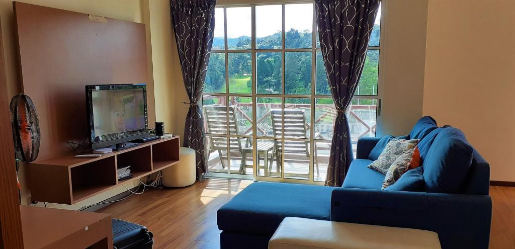 金马仑高原提亚斯公寓@艾利斯之家度假村的客厅设有蓝色的沙发和大窗户