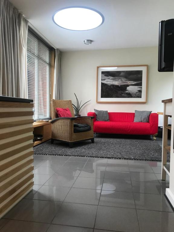 科隆bel xanto的客厅配有红色的沙发和椅子