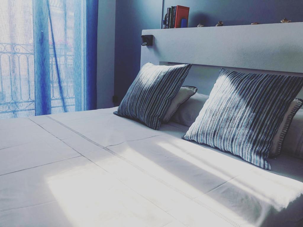 卡斯泰拉马莱Calida B&B的一张带两个枕头的白色床和窗户