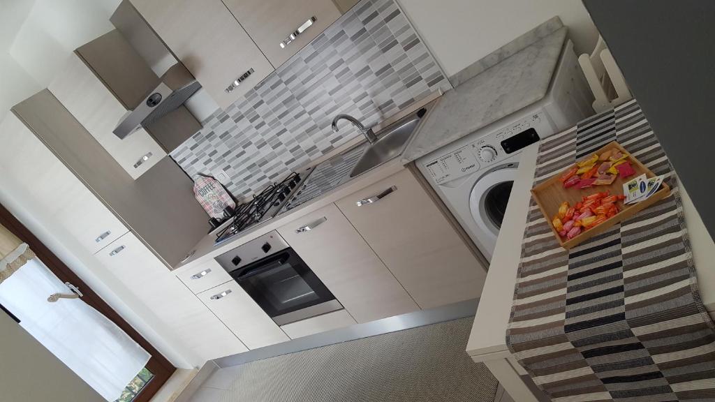 恩纳La casa in piazzetta的白色的厨房配有水槽和洗碗机