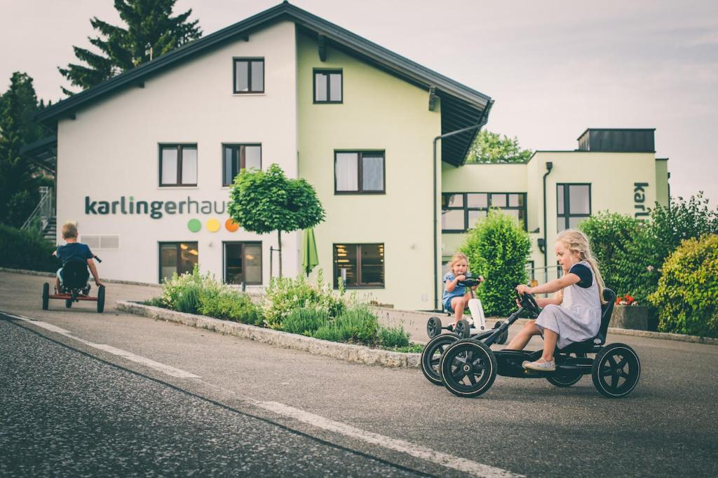 Königswiesen卡林格豪斯旅馆的一群儿童在街上的玩具车上骑着