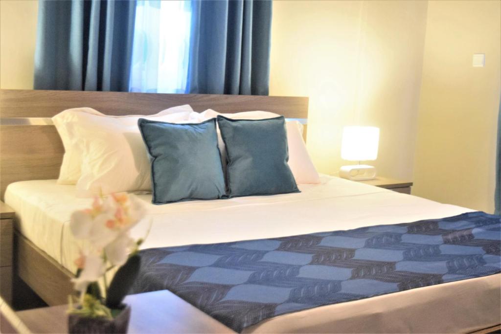 阿克拉Montecito Apartments的一间卧室配有一张带蓝色和白色枕头的床