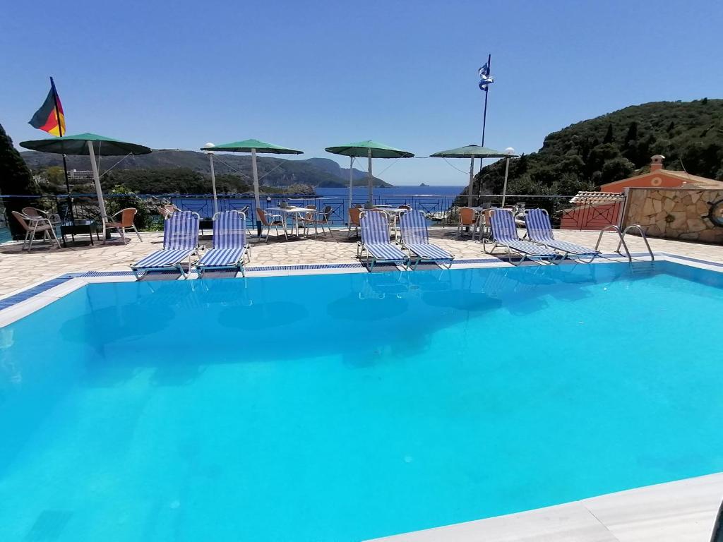 帕莱欧卡斯提撒George Michalas (Vivaria Apartments)的一个带椅子和遮阳伞的大型游泳池