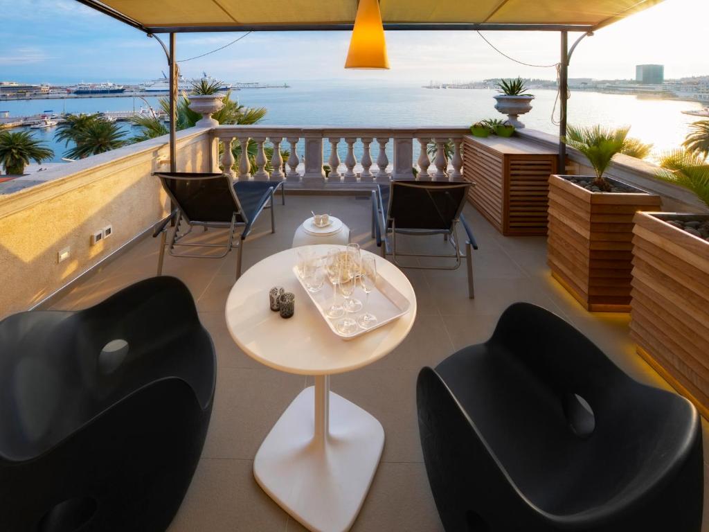 斯普利特里瓦豪华套房酒店的阳台配有桌椅,享有水景。