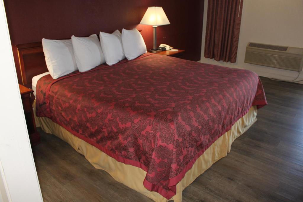 比福德Travel Inn of Buford的酒店客房设有一张带红色毯子的大床