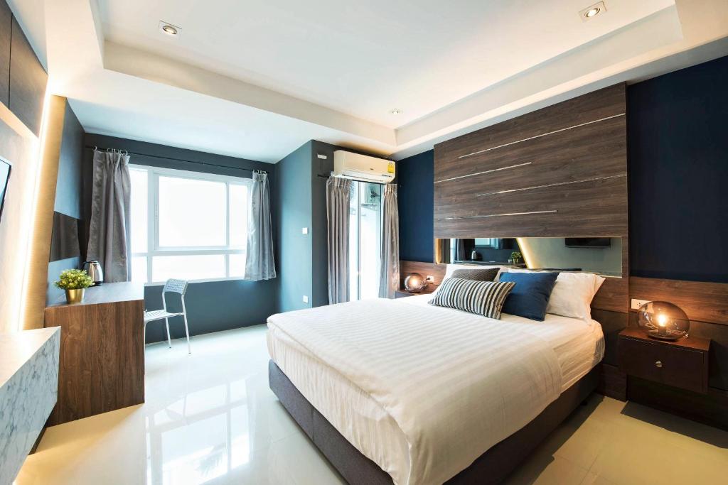 曼那拉塞尔59NW公寓式酒店的一间卧室设有一张大床和蓝色的墙壁