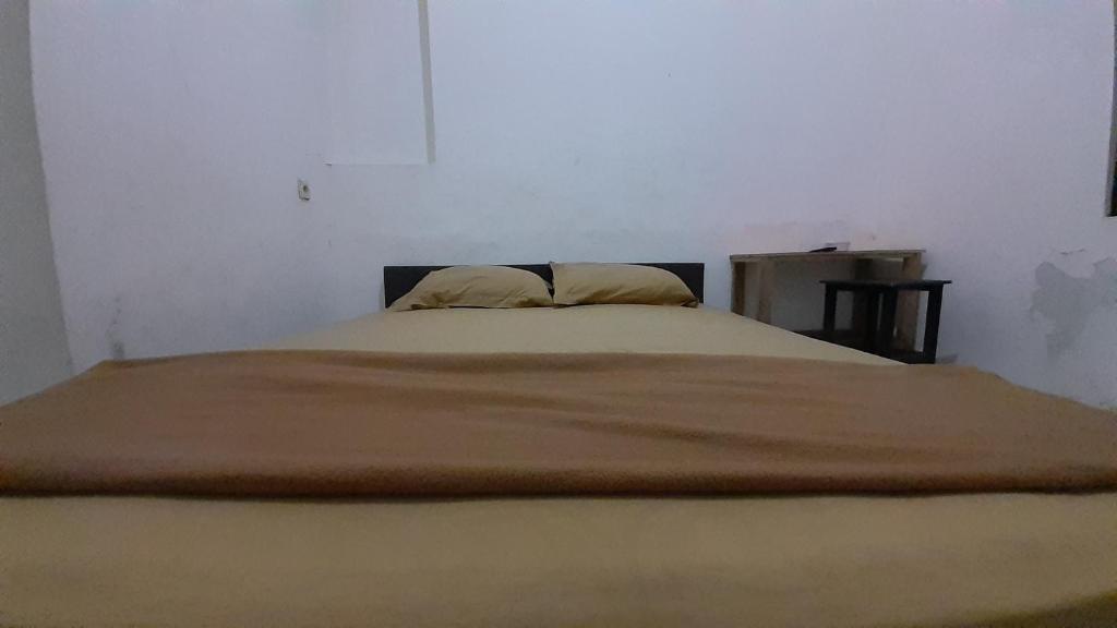 贝克西Rumah Rahman Syari'ah的卧室内的一张带两个枕头的床