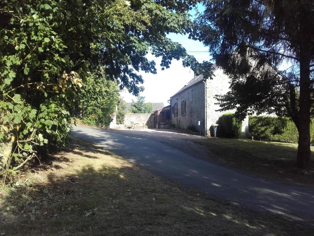 Pierrefitte-en-CinglaisL' ancien pressoir 2的一条空的路,边有一座建筑和树木