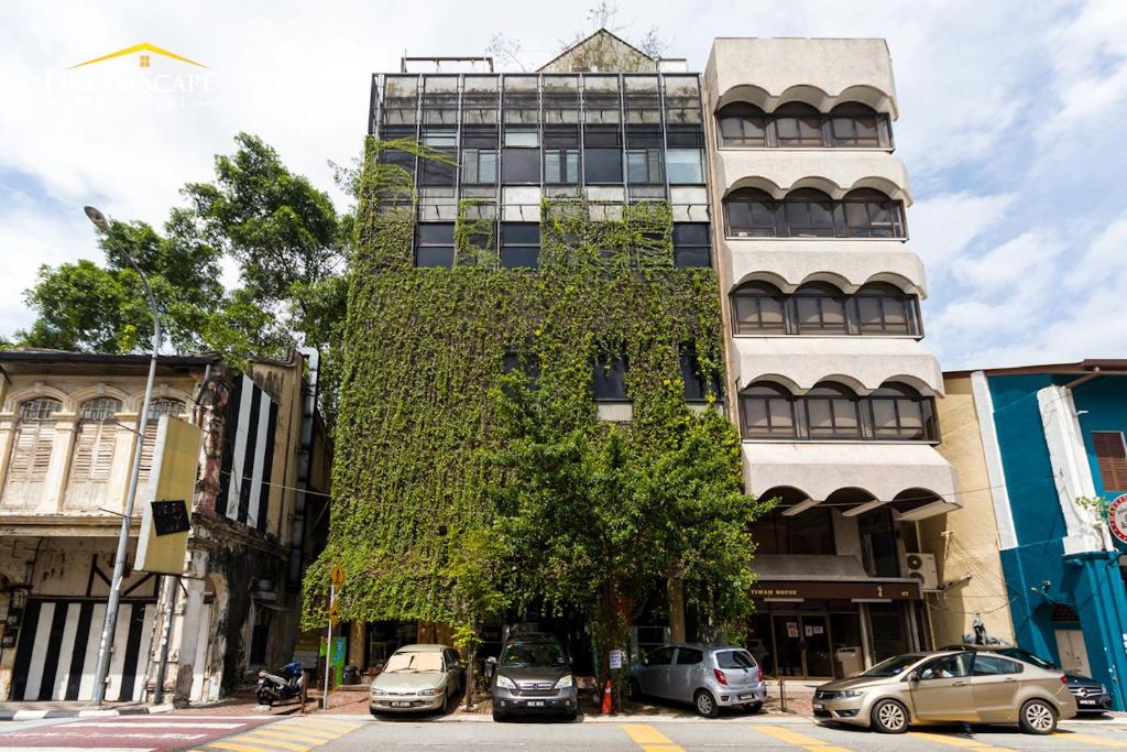 怡保Belakang KongHeng By DreamScape的一座常春藤生长在它的一侧的建筑