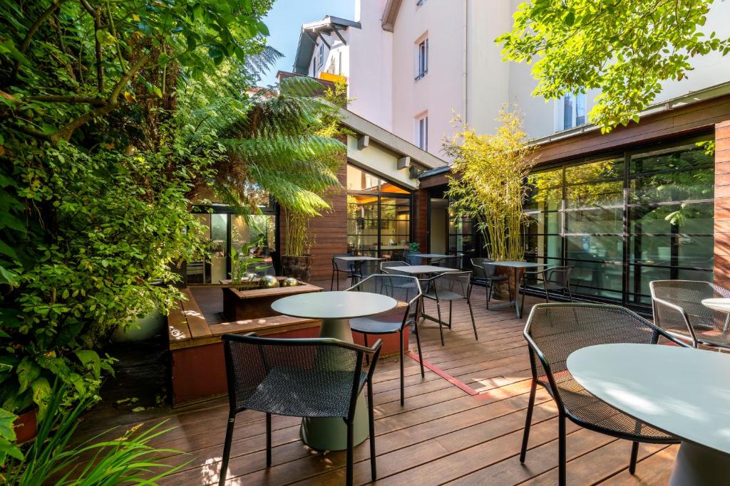 比亚里茨Hotel Villa Koegui Biarritz的户外庭院设有桌椅和植物