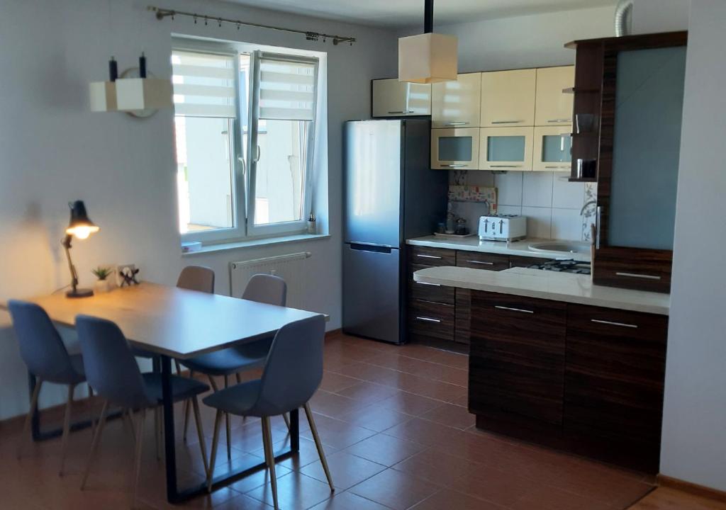 奥古斯图Apartament dwupoziomowy的厨房配有桌子和蓝色冰箱。