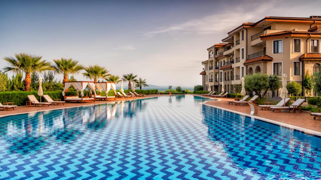 布尔加斯Burgas Beach Resort Apartments的一座带椅子和建筑的大型游泳池