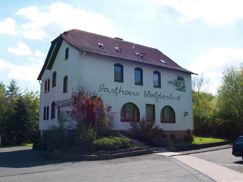 埃斯彭瑙Gästehaus Waldeslust的白色的建筑,旁边标有标志