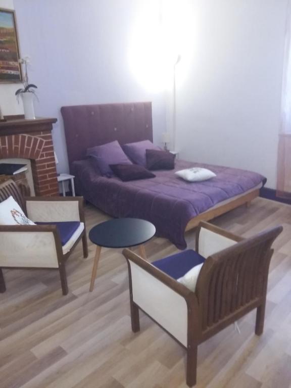 马扎梅Quai de l ' Arnette的一间卧室配有一张床、两把椅子和一张桌子