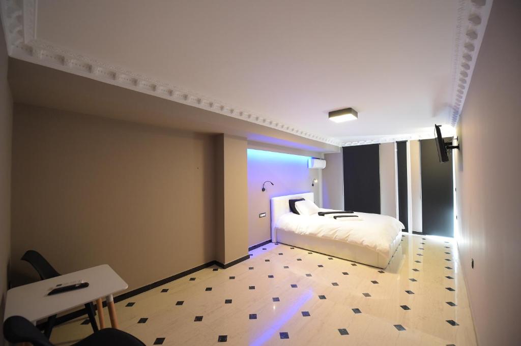 帕特雷Pietra Mare Suites的一间白色床和蓝色灯的卧室