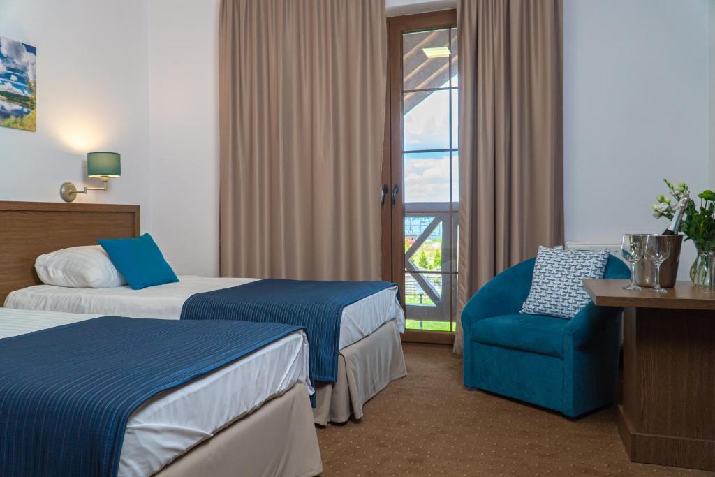 涅波伦特HOTEL CICHA WODA NIEPORĘT的酒店客房带两张床、椅子和窗户