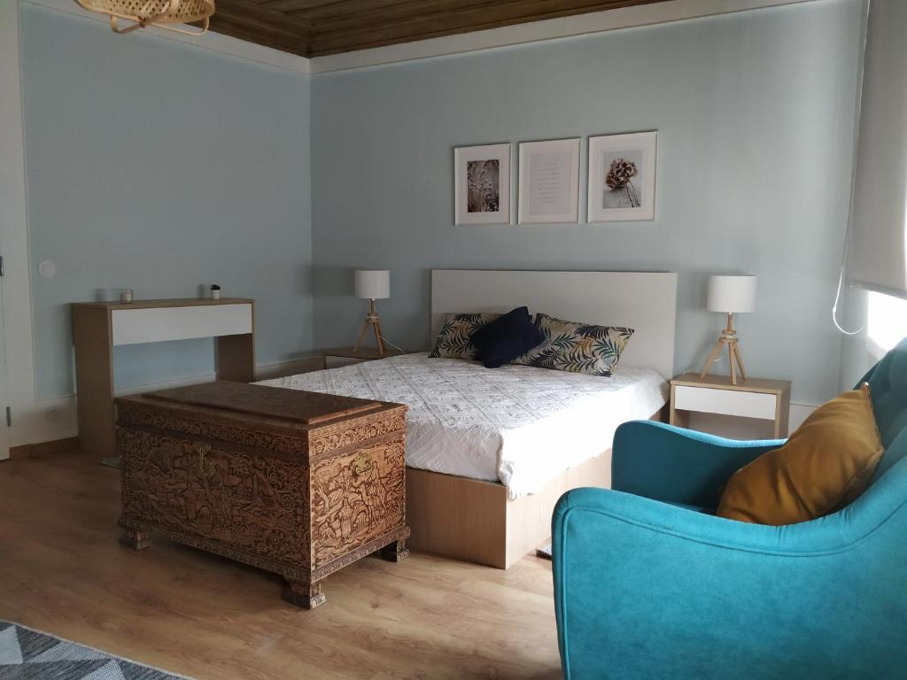 洛里加EntreSocalcos的一间卧室配有一张床和一张蓝色椅子