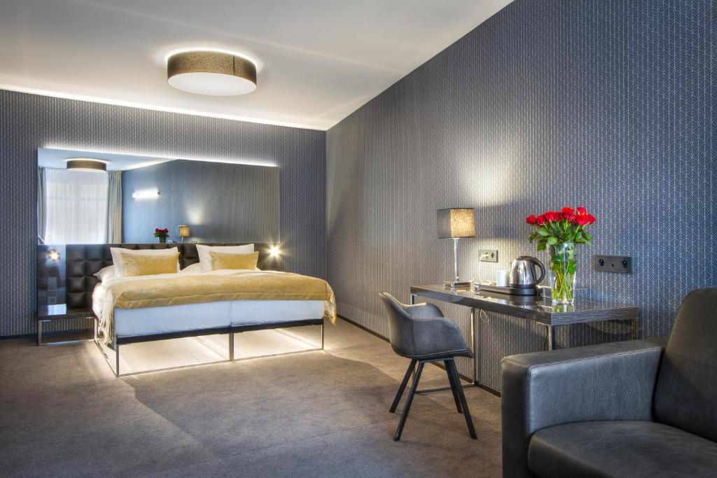 布拉格木栅酒店的一间卧室配有一张床、一张桌子和一张沙发