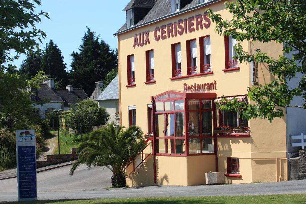 拉福雷富埃南Maison Hôtel Aux Cerisiers的黄色的建筑,前面有标志