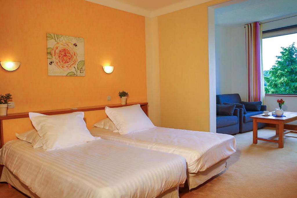 纳雅克L'Oustal Del Barry的酒店客房,设有两张床和一张沙发