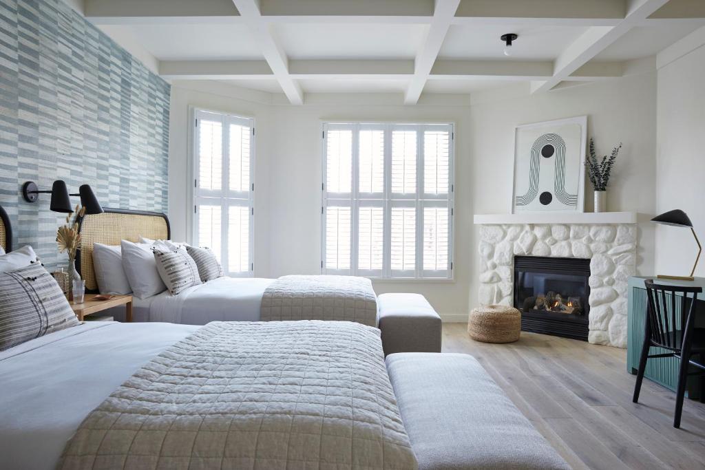 圣路易斯-奥比斯保圣路易斯朗泉旅舍的一间卧室设有两张床和一个壁炉