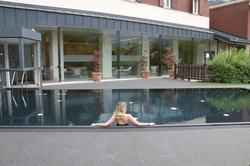 库马约尔皇家高尔夫豪华酒店的坐在游泳池边缘的女人