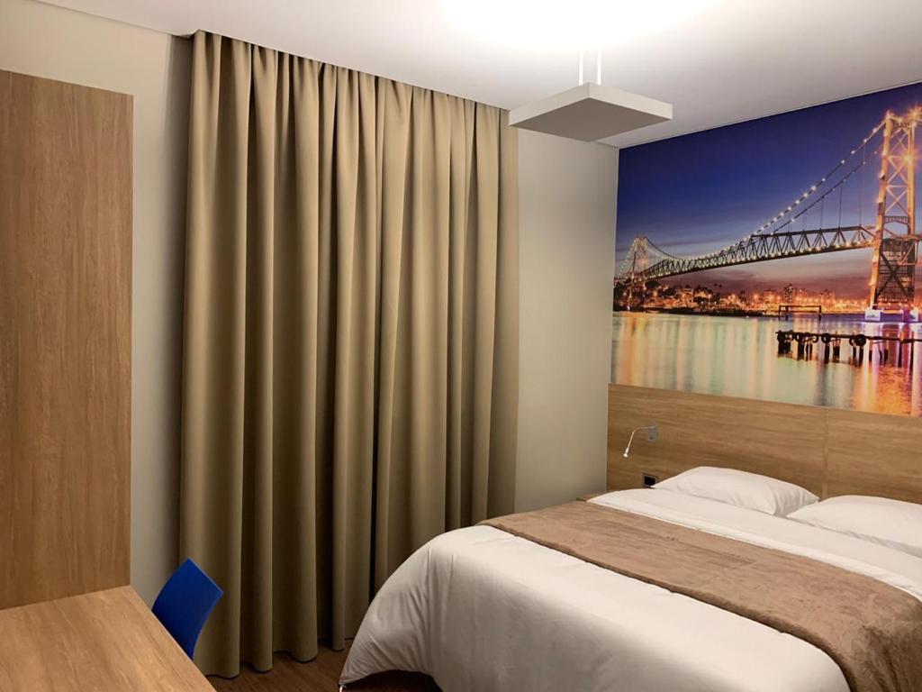 南大坎皮纳Hotelog的一间卧室,配有一张带桥梁画的床铺
