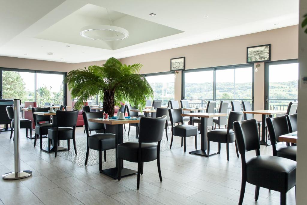 滨海克里耶勒Hotel Les Galets的餐厅设有桌椅和窗户。