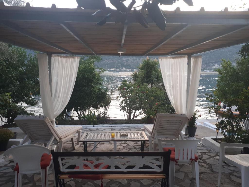 耶尼翁Geni Bay的一个带椅子和桌子的庭院,享有水景