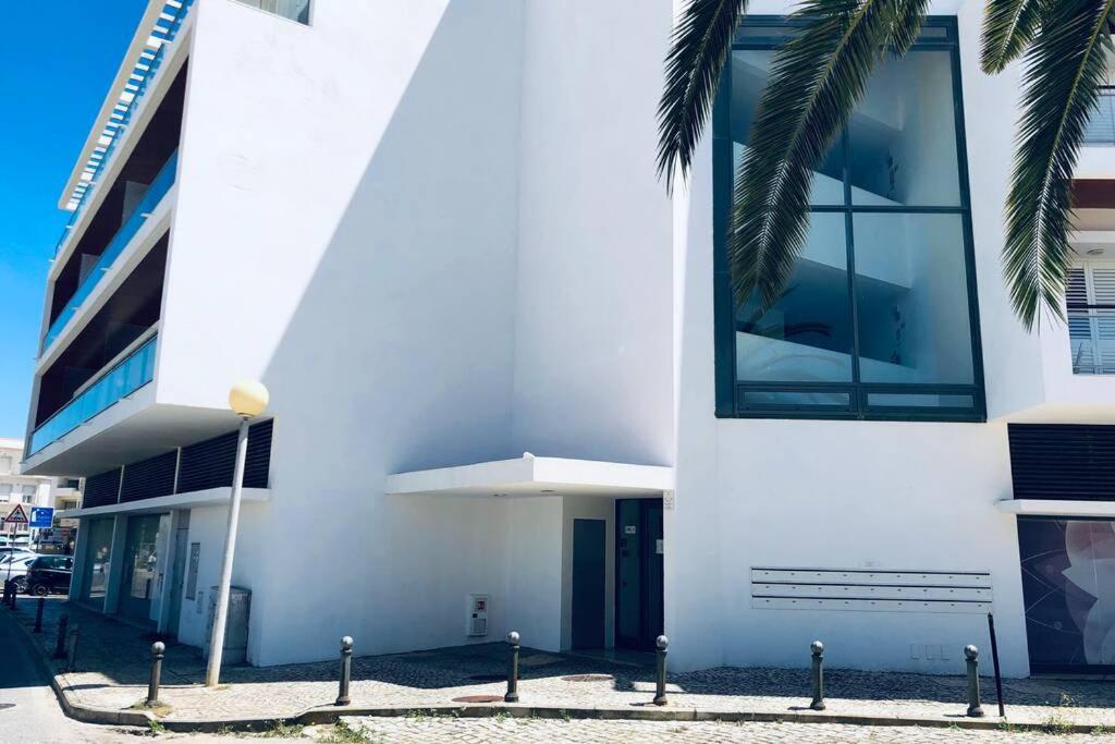 阿尔布费拉Vacations home Albufeira的一座白色的建筑,前面有棕榈树