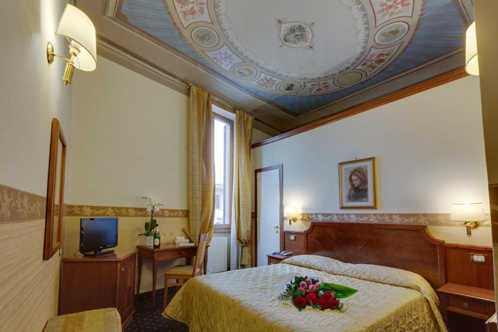 佛罗伦萨亚利桑那酒店的一间酒店客房,床上摆放着鲜花