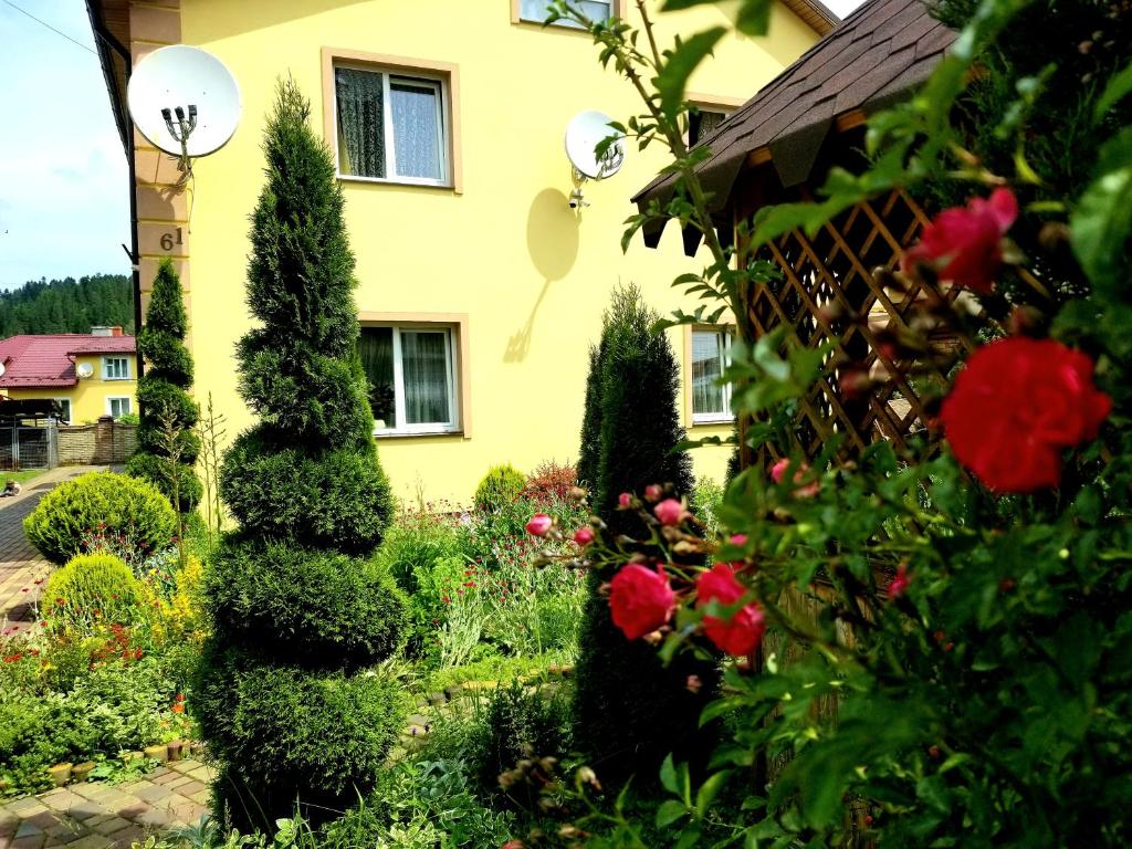 斯基希德尼萨Садиба Святослав的玫瑰黄色房子前面的花园