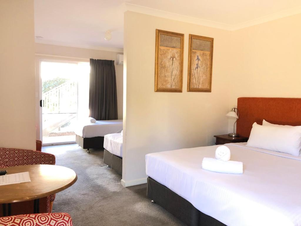 玛格丽特河Higgins Lane Motel的酒店客房设有两张床和一张桌子。