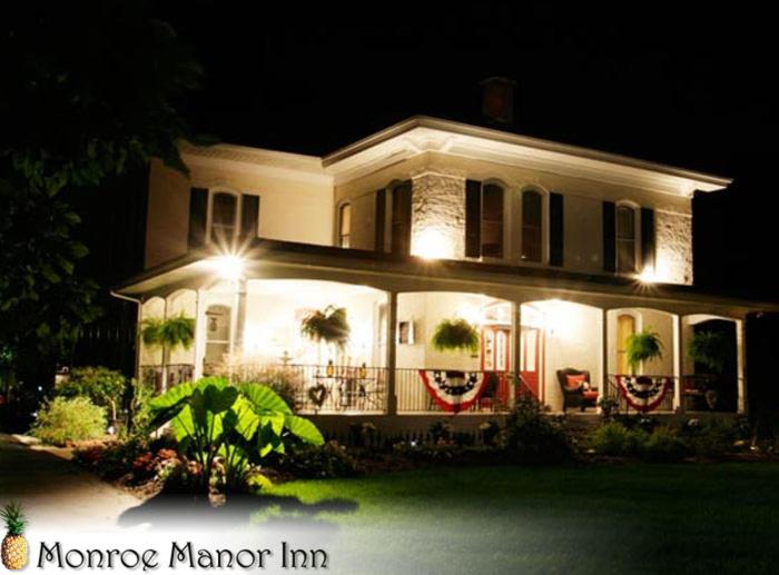 南黑文Monroe Manor Inn的夜晚有灯的大白色房子