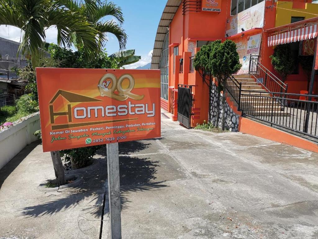 TakengonQQ HOMESTAY的建筑前的橙色标志