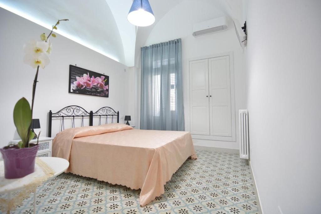 卡斯特里尼亚诺德尔卡波Lu Trisciulu的一间卧室配有一张床和盆栽植物