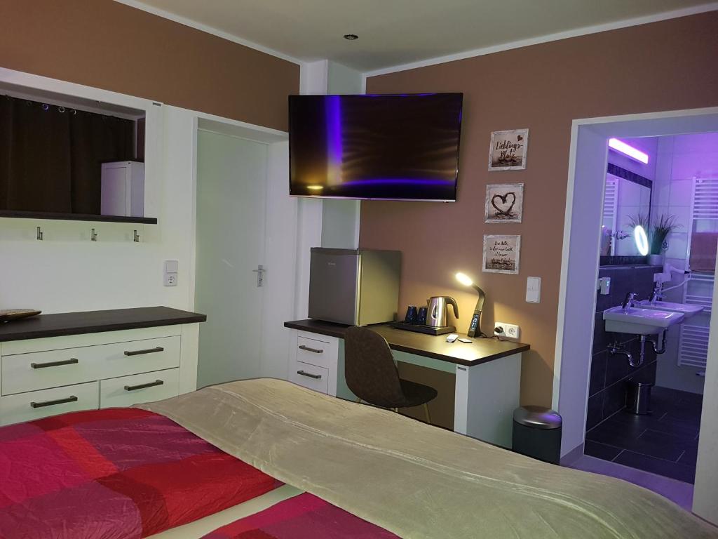 开姆尼茨Pension Hoefti的一间卧室配有一张床、一张书桌和一台电视。