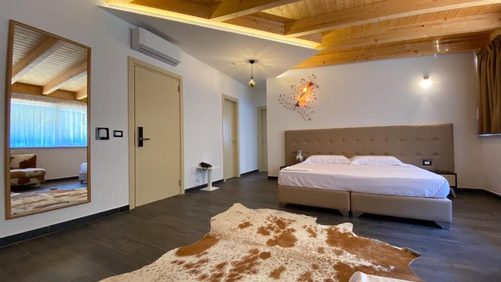 圣金Mille Amici Hotel的一间大卧室,配有床和地毯