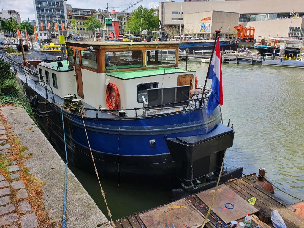 鹿特丹Houseboat holiday apartments Rotterdam的蓝白的船坐在水里