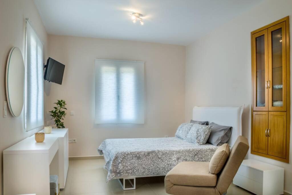 迈萨纳Blanca Serenidad Luxury Apartment的白色卧室配有床和椅子