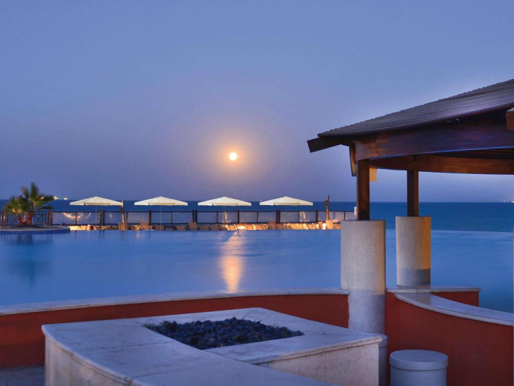 艾因苏赫纳艾尔索克纳瑞享酒店 的享有夜间带游泳池的度假村景色
