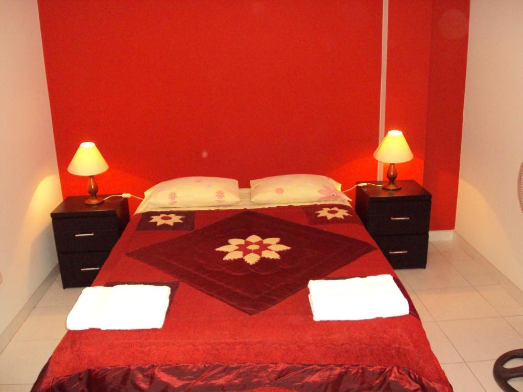 纳斯卡纳斯卡旅舍的红色卧室配有一张红色的床铺和两盏灯