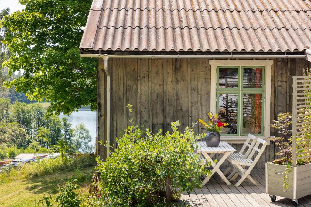 格内斯塔Sustainable and soulful close to lake的木制房屋,在甲板上配有桌椅
