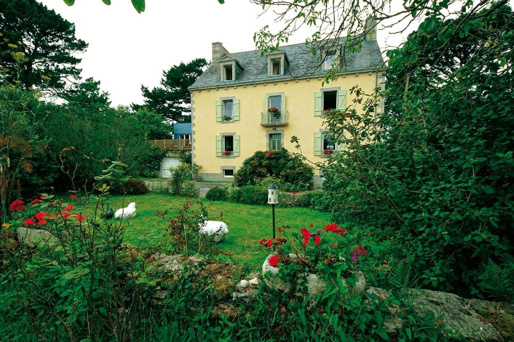 孔卡尔诺Maison de Kersalomon的院子里有动物的大型黄色房子