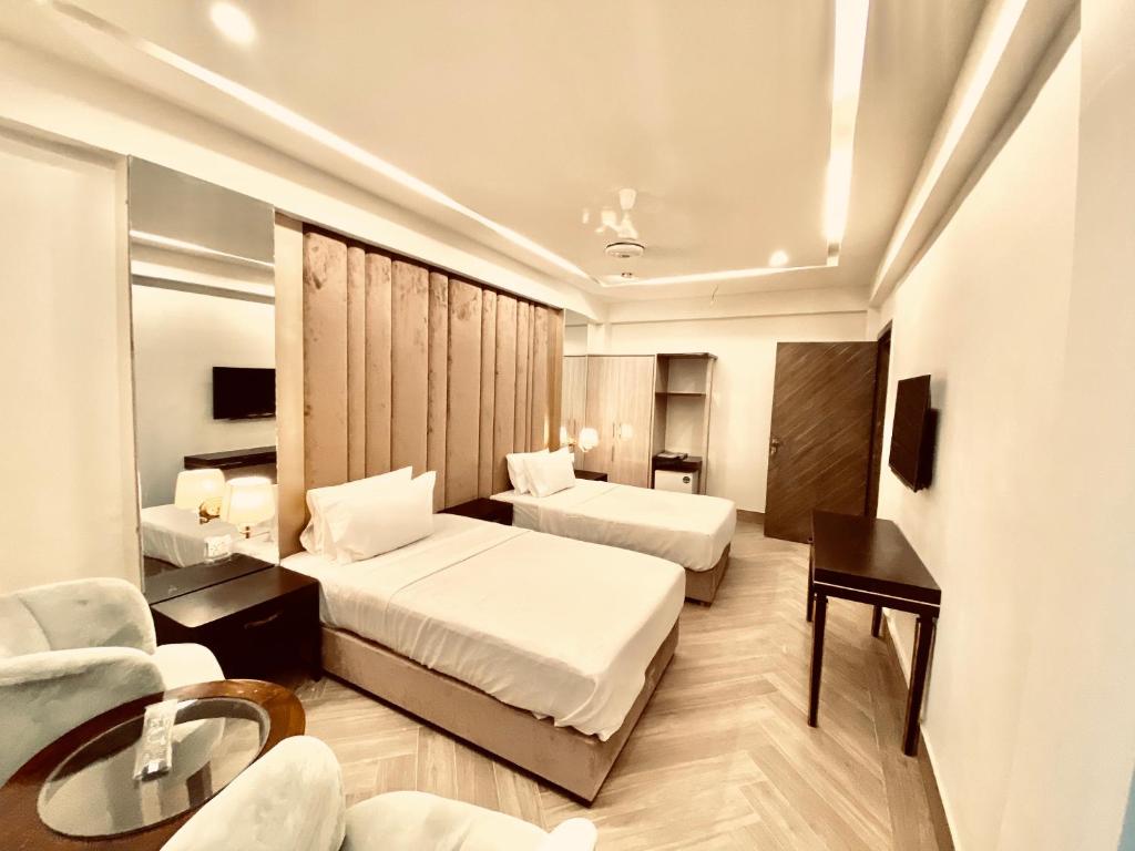 伊斯兰堡Shelton's Ambassador的酒店客房设有两张床和一张桌子。